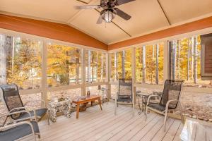 a room with chairs and a table and windows at Whispering Pines in Thompsonville