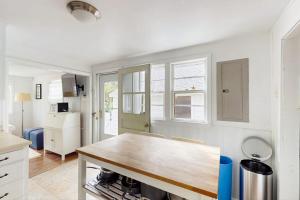 a kitchen with a wooden table in a room at The Kettle Cottage in Cotuit
