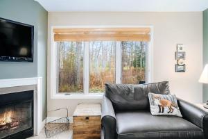 a living room with a leather couch and a fireplace at Wintergreen Condo, Unit 540 in Thompsonville
