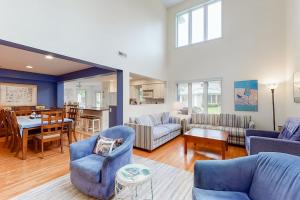 a living room with blue furniture and a dining room at Sea Colony - 56010 Pine Shore in Bethany Beach
