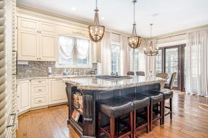 a kitchen with a large island with black bar stools at Eagles Nest in New Buffalo +41 photos