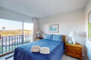 a bedroom with a blue bed and a balcony at Gentle Winds 9 10 in Glen Arbor +6 photos