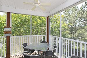 a table and chairs on a porch with a ceiling fan at Sea Colony - 55021 Pine Lake in Bethany Beach