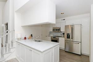 a kitchen with white cabinets and a stainless steel refrigerator at Sea Colony - 55021 Pine Lake in Bethany Beach +32 photos