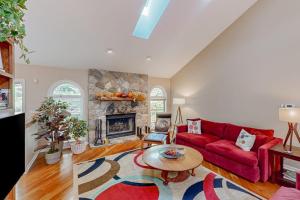 a living room with a red couch and a fireplace at Betsie Woods in Thompsonville