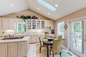 a kitchen with white cabinets and a table and chairs at Betsie Woods in Thompsonville