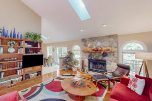 a living room with a fireplace and a table at Betsie Woods in Thompsonville