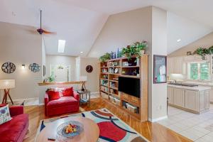 a living room with a red couch and a tv at Betsie Woods in Thompsonville