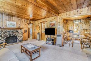 a living room with a stone fireplace and a tv at Hal's Hideaway in Beulah