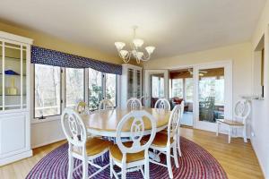 a dining room with a wooden table and white chairs at Heron Creek in Laketown Township