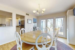a dining room with a wooden table and white chairs at Heron Creek in Laketown Township