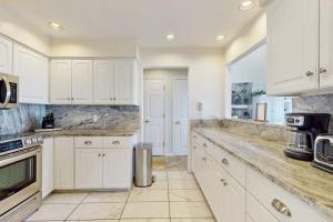 a kitchen with white cabinets and marble counter tops at Heron Creek in Laketown Township +19 photos