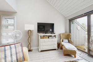 a living room with a tv and a chair at Wilderness 9 in Glen Arbor