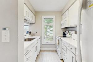 a kitchen with white cabinets and a window at Wilderness 9 in Glen Arbor