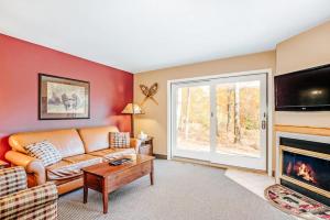 a living room with a couch and a fireplace at Crystal Mountain Condo - Wintergreen 535 in Thompsonville