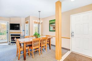 a dining room with a wooden table and chairs at Crystal Mountain Condo - Wintergreen 535 in Thompsonville +18 photos