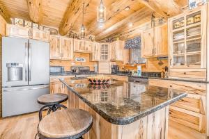 a large kitchen with wooden cabinets and a refrigerator at Salmon Run in Thompsonville