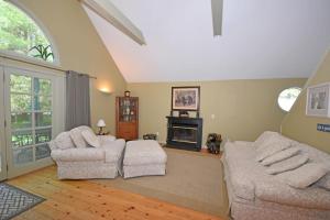 a living room with two chairs and a fireplace at Dancin' Bear in Glen Arbor