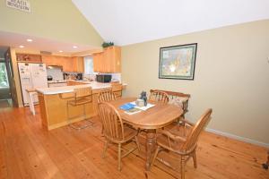 a kitchen and dining room with a wooden table and chairs at Dancin' Bear in Glen Arbor