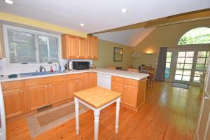 a kitchen with wooden cabinets and a table in it at Dancin' Bear in Glen Arbor +14 photos