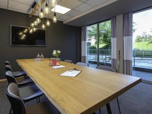 a conference room with a large wooden table and chairs at ibis Aalst in Aalst