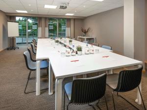 a large conference room with a large white table and chairs at ibis Aalst in Aalst