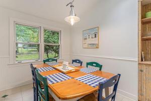 a dining room with a wooden table and chairs at Painted Porch Cottage in Lakeside +21 photos
