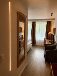 a living room with a mirror and a couch at Hotel Night4Flight Hamburg-Airport in Hamburg