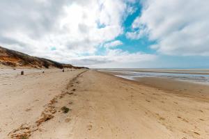 a sandy beach with footprints in the sand at Life's Better at the Beach in Eastham