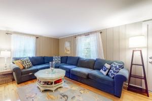 a living room with a blue couch and a table at Life's Better at the Beach in Eastham
