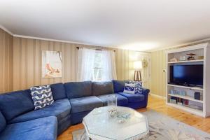 a living room with a blue couch and a table at Life's Better at the Beach in Eastham