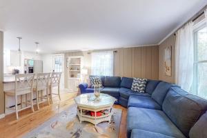 a living room with a blue couch and a table at Life's Better at the Beach in Eastham +25 photos