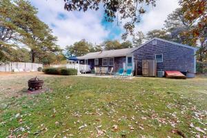 a blue house with a grill in a yard at Life's Better at the Beach in Eastham