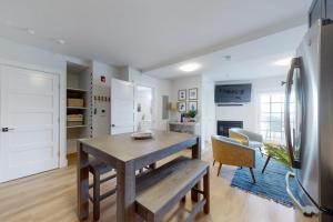 a kitchen and dining room with a table and a refrigerator at Villa Balena - A Cape Cod Oasis in Dennis Port