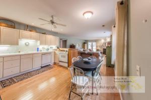 a kitchen with white cabinets and a table and chairs at La Colita in Harbert