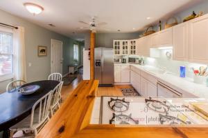 a kitchen with a table and a refrigerator at La Colita in Harbert