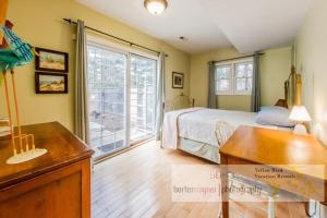 a bedroom with a bed and a large window at La Colita in Harbert