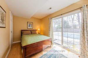 a bedroom with a bed and a large window at La Colita in Harbert