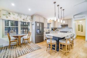 a kitchen with a table and chairs and a kitchen with white cabinets at Red Pine Retreat in Thompsonville