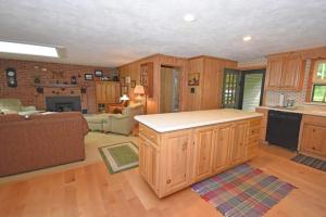 a kitchen with wooden cabinets and a living room at Thorogood Glen in Empire