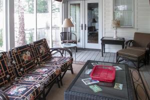 a porch with two couches and a table with a red bag at Azure Forest Pool House in Union Pier