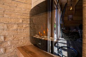 a stone wall with a fireplace with a wooden bench at Bugen Villa II in Žabljak
