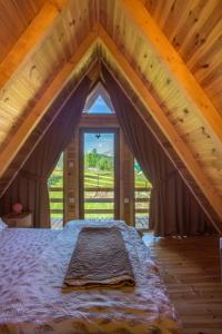 a bed in a room with a large window at Bugen Villa II in Žabljak