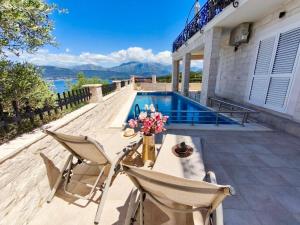 a villa with a swimming pool and a house at Villa Mare Apartments in Tivat