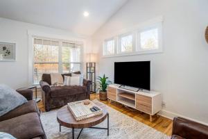 a living room with a couch and a flat screen tv at Borrowed Thyme in Saugatuck