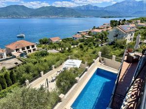 a villa with a swimming pool next to a body of water at Villa Mare Apartments in Tivat