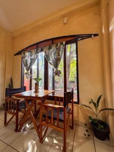 a dining room table and chairs in front of a window at Benteveo hostel iguazu in Puerto Iguazú
