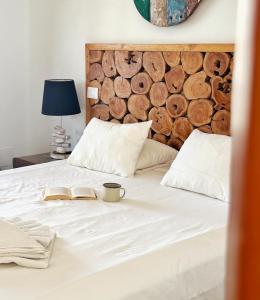 a bed with a book and a cup on it at Casa Lava in Punta Mujeres