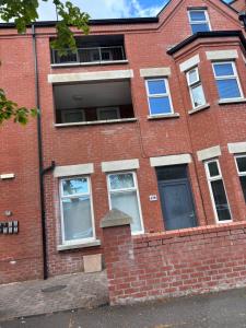 a red brick building with windows and a door at Queens apartments Belfast in Belfast