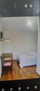 a small bedroom with a bed and a table at Hotel Centro Sul in Anastácio